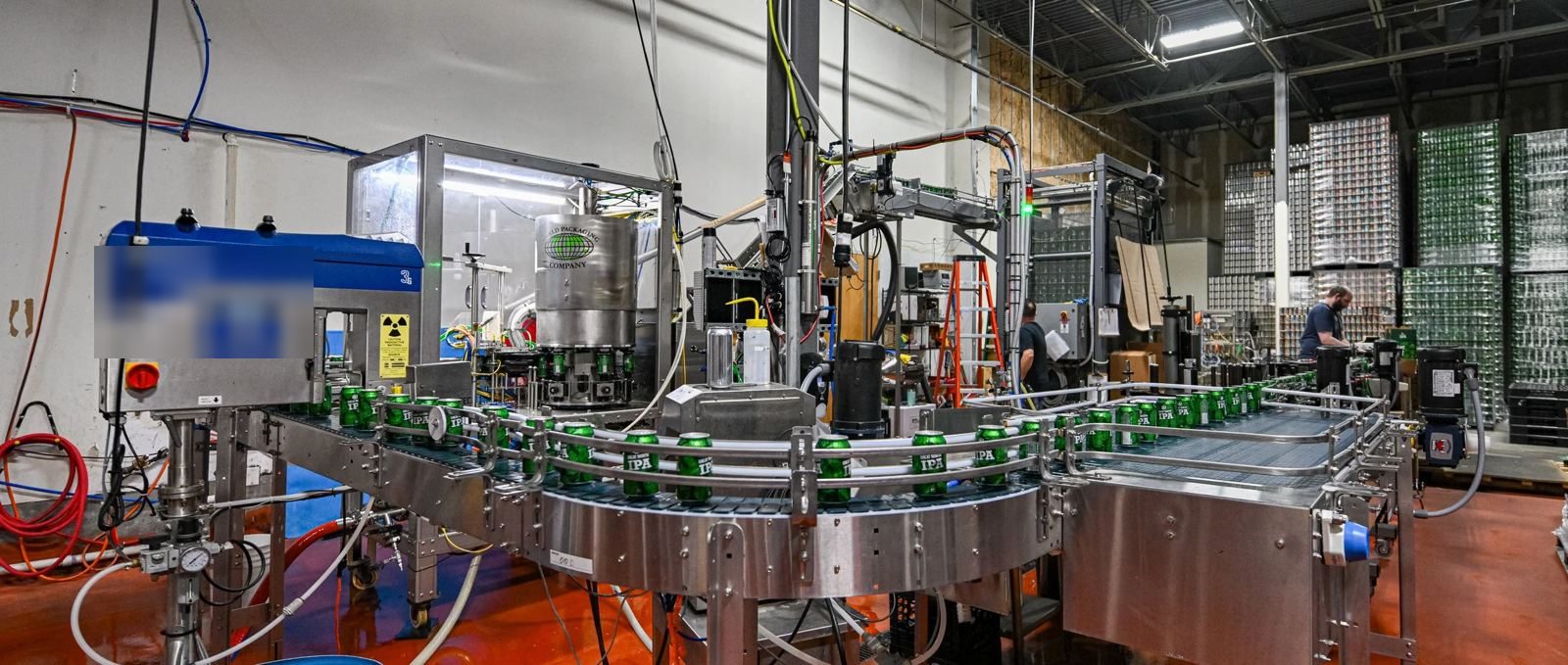 Small-format canning line with conveyors around a counter-pressure filler