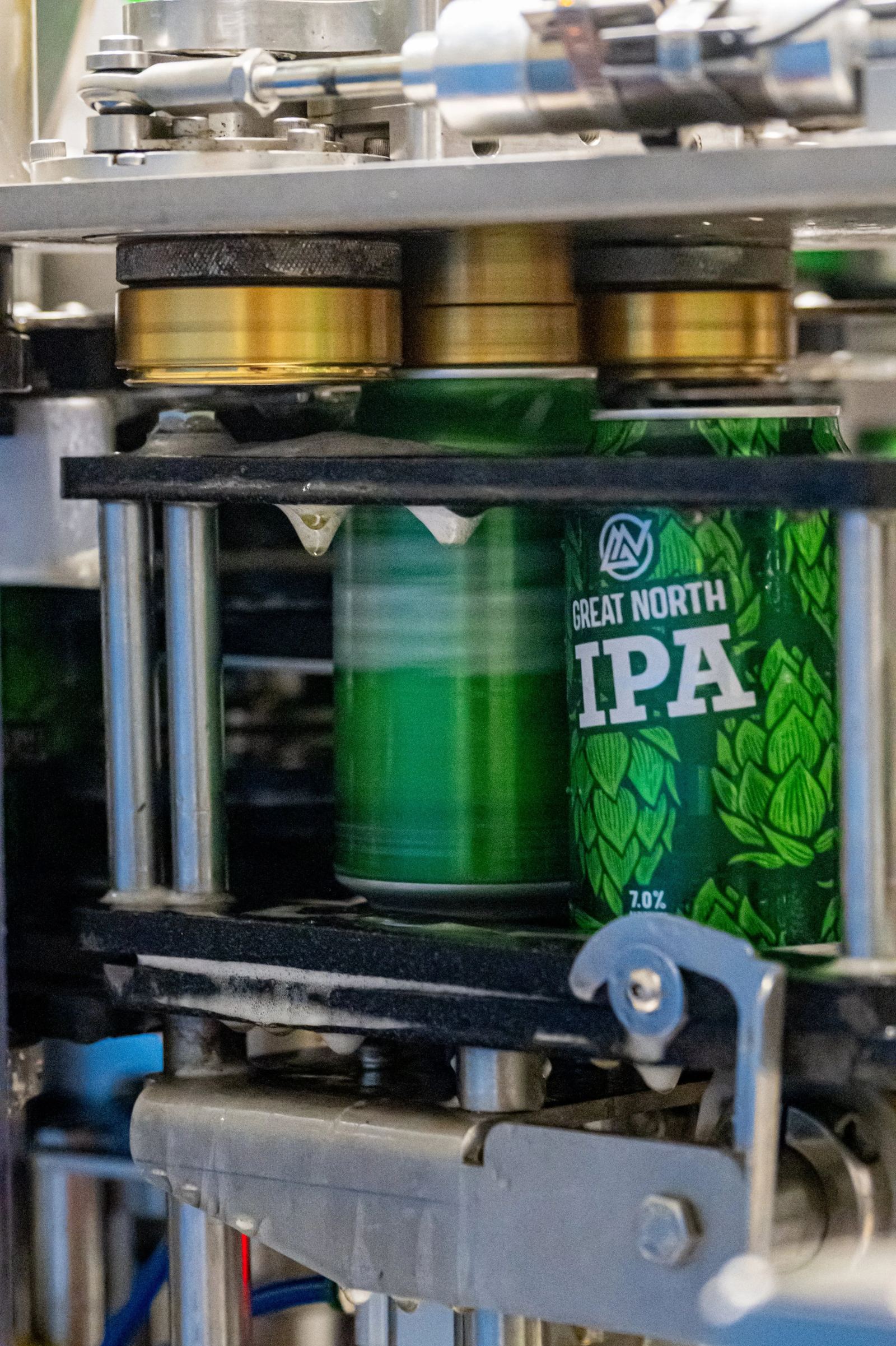 Cans moving through a counter-pressure filler and seamer